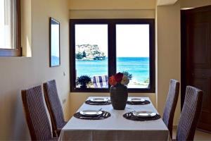 a dining room with a table with a view of the ocean at Dreamwave Residence - Unique holidays by the sea in Lygaria