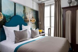 a bedroom with a large bed with a painting on the wall at Hôtel & Spa Vinci Due in Paris