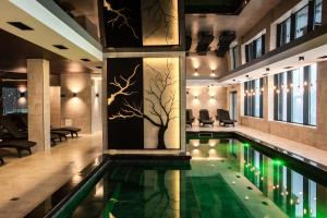 a pool in a building with a tree on the wall at Premium Club SPA in Bukovel
