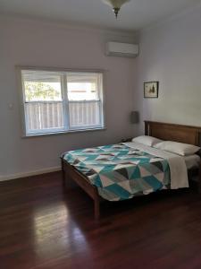 a bedroom with a bed and a window at Fremantle Colonial Home in Fremantle