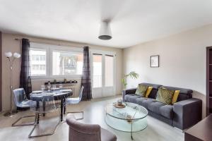 a living room with a couch and a table at LORGERIL -appartement 2 chambres proche Mail in Rennes