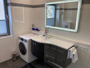 a bathroom with a sink and a washing machine at Cityapartment An der Petrikirche in Braunschweig +34 photos