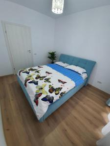 Schlafzimmer mit einem Bett mit blauem Kopfteil in der Unterkunft Apartament 3 camere militari residence in Roşu