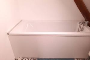 een wit bad met een wastafel in de badkamer bij Loft de charme á 150m de la cathédrale in Beauvais