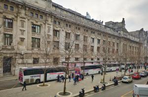 una calle de la ciudad con autobuses estacionados frente a un edificio en Hotel Central Station, en Milán