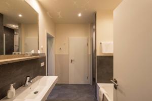 a bathroom with a sink and a mirror at Hotel Deutschherrenhof in Zeltingen-Rachtig