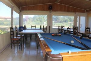 a pool room with two tables and chairs at Hostal Can Bassalis in Pals