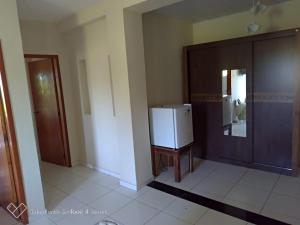 a room with a refrigerator and a wooden door at HOTEL PRAIA DA PAIXÃO in Prado