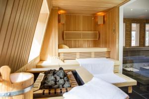 a room with a sauna with a fireplace and a tub at Hotel Deutschherrenhof in Zeltingen-Rachtig