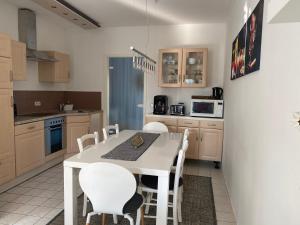 a kitchen with a white table and white chairs at Nordwind in Boltenhagen