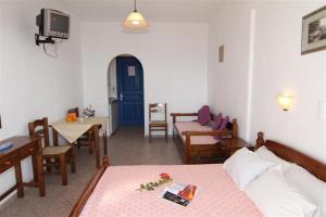 a living room with a bed and a table and a tv at Studios Vagos 2 in Agios Prokopios