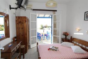 a bedroom with a bed and a desk and a table at Studios Vagos 2 in Agios Prokopios