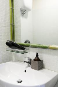 ein Waschbecken mit einem Seifenspender darüber in der Unterkunft Opera Suites - Il sentiero della felicità in Calcata