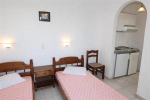a small room with two beds and a kitchen at Studios Vagos 2 in Agios Prokopios +26 photos