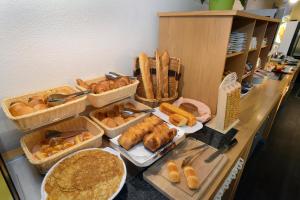 un buffet con cestas de pan y bollería en una barra en Hotel inn Dijon-Quetigny, en Quetigny