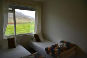 um pequeno quarto com uma janela, uma cama e uma janela em Kaffi Holar Cottages and Apartments em Sauðárkrókur