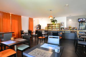 un restaurant avec des tables et des chaises ainsi qu'un bar dans l'établissement Hotel inn Dijon-Quetigny, à Quetigny