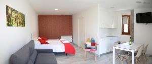 a bedroom with a bed and a desk and a kitchen at Apartamentos Aldagaia in Hernani