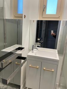 a white bathroom with a sink and a mirror at EVASION DE LOIRE in Jargeau