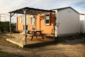 Cabaña con mesa de picnic en la cubierta en Camping 3 Estrellas, en Gavà