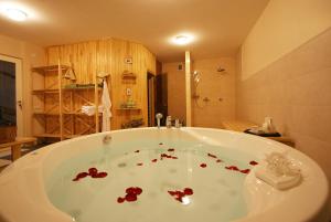 a large bath tub with red flowers in a bathroom at Baltas Namas in Palanga