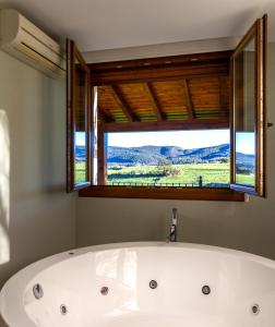a bath tub in a bathroom with a window at Posada Valle de Güemes in Güemes +34 photos