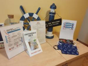 a table topped with signs and a bottle of water at Amberek Dom Gościnny in Międzyzdroje