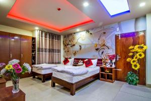 a bedroom with two beds and flowers on the wall at Hotel Pushpo Bilash in Khulna