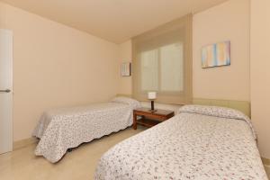 トロクス・コスタにあるPrecioso apartamento de 2 dormitorios con parking & WiFiのベッドルーム1室(ベッド2台、窓付)