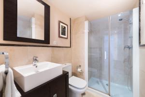 a bathroom with a white sink and a shower at Precioso apartamento de 2 dormitorios con parking & WiFi in Torrox Costa +6 photos