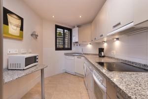 una cucina con lavandino e forno a microonde di Spacious 3 bedrooms apartment side sea view a Torrox Costa