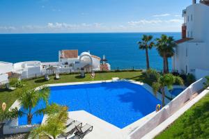 a swimming pool with a view of the ocean at Fantástico apartamento de 1 dormitorio frente al mar in Torrox Costa