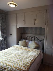 een slaapkamer met een groot bed en witte kasten bij Westhouse Cafe in Longford