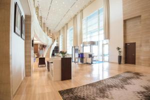 an office lobby with a reception desk and a large window at dusitD2 Salwa Doha in Doha