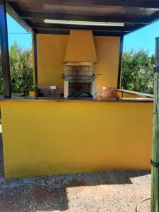 a yellow kitchen with a stove top oven at EL REFUGIO DE POPEA in Santa María de Trassierra