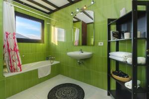 a green bathroom with a sink and a mirror at Casa Clara 3 in Conil +21 photos