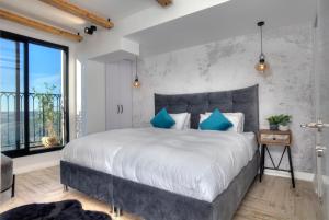 a bedroom with a large bed with blue pillows at Open Skys in Safed