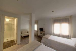 une chambre d'hôtel avec deux lits et un bureau ainsi qu'une chambre dans l'établissement El Mirador de Candelario, à Candelario