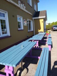 una fila di tavoli da picnic fuori da una caffetteria di Westhouse Cafe a Longford