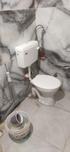 W pokoju znajduje się łazienka z białą toaletą. w obiekcie Tanish Homestay w mieście Bharbharia