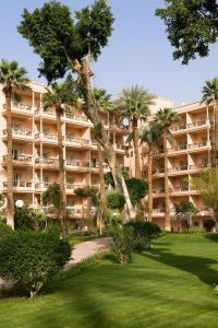 a large apartment building with palm trees in a park at Pavillon Winter Luxor in Luxor