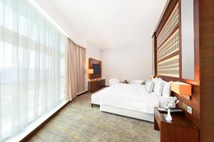 Een bed of bedden in een kamer bij dusitD2 Salwa Doha