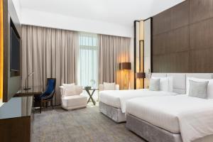 Een bed of bedden in een kamer bij dusitD2 Salwa Doha