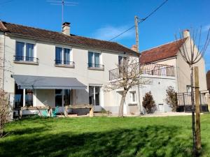 una gran casa blanca con césped delante en Les ammonites gîte de charme en Bourgogne, en Guillon