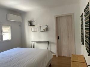 a white bedroom with a bed and a door at Casa Carmo in Évora