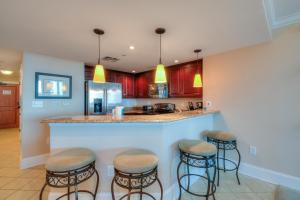 a kitchen with a bar with four stools at Mar Vista Grande by Palmetto Vacation Rentals in Myrtle Beach
