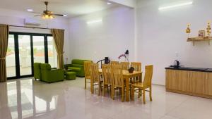 a dining room with a table and a green couch at Hue Classic Hotel in Hue