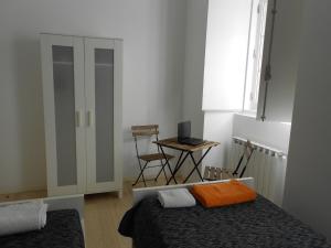 um quarto com 2 camas e uma secretária com um computador portátil em Triplex - Quarto com w.c. privado em Lisboa