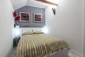 een slaapkamer met een bed en twee foto's aan de muur bij ,,La Chaumière d’Azur” in Roquebrune-Cap-Martin