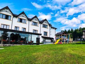 a large house with a playground and a slide at Hotel Complex Dvir Kniazhoiy Korony in Slavske